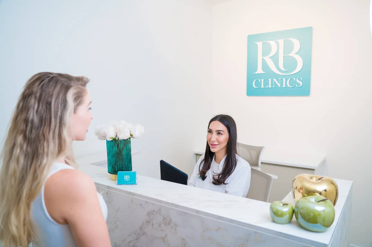 Client wordt ontvangen bij de receptie van RB Clinics Amsterdam