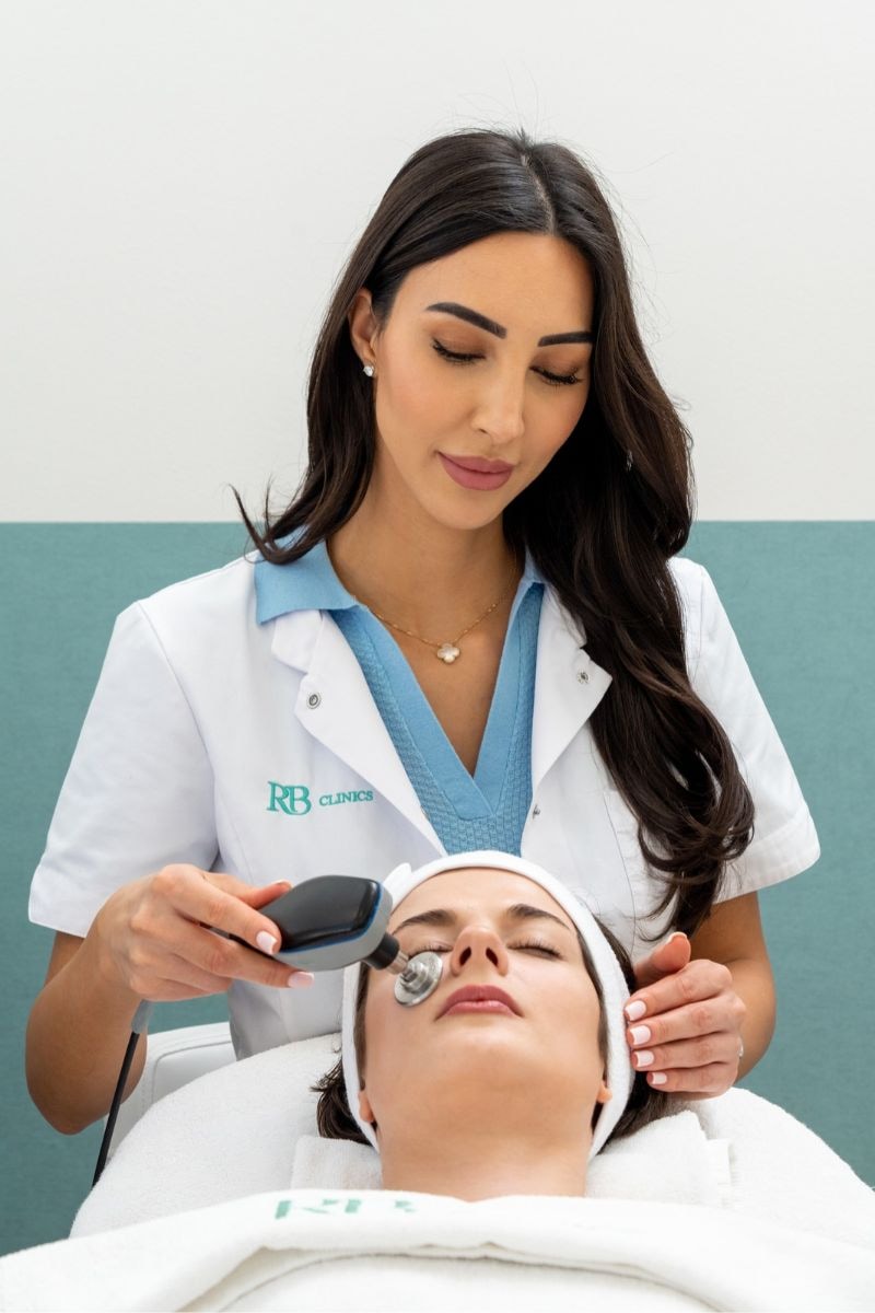 Specialist van RB Clinics behandelt het gezicht van een cliënte met de Indiba applicator